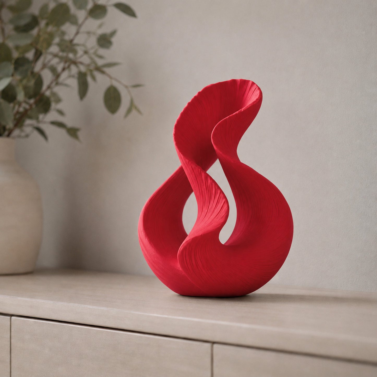 Escultura decorativa com duas curvas entrelaçadas, na cor vermelha