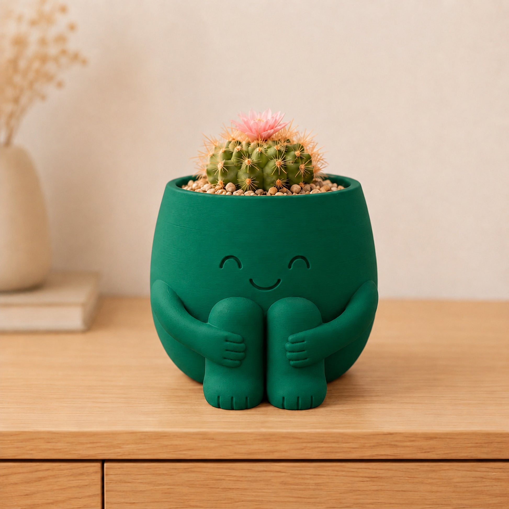 Vaso amiguinho sentado abraçando os joelhos, com carinha de olhos fechados, na cor verde escura