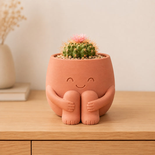 Vaso amiguinho marrom terracota sentado abraçando os joelhos, com carinha de olhos fechados
