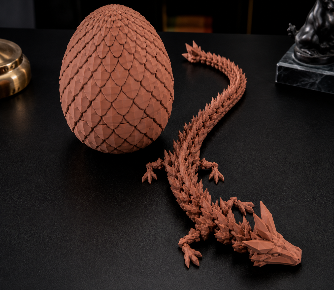 Ovo de dragão que se abre revelando um dragão articulado, na cor marrom terracota