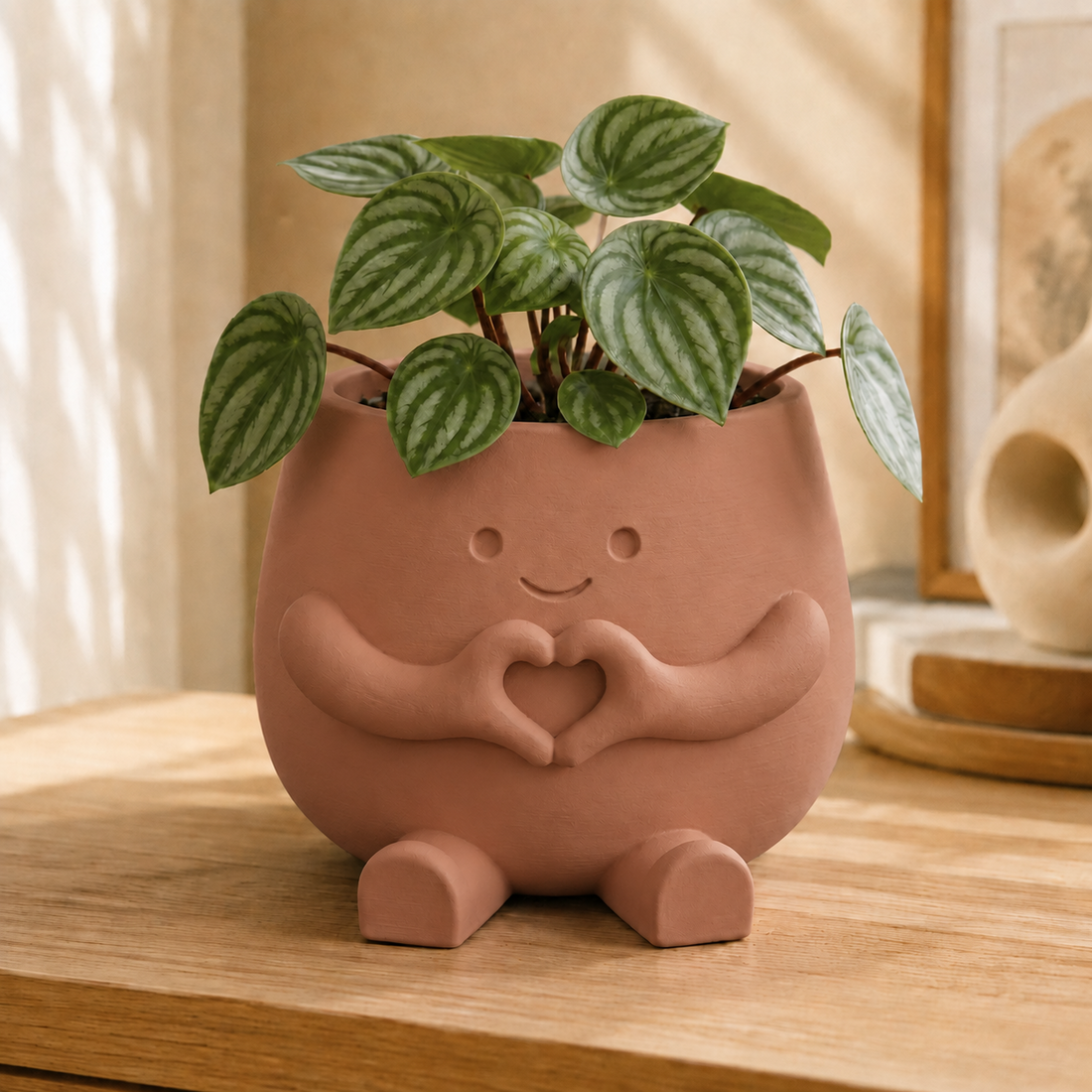 Vaso amiguinho com carinha sorridente e mãos fazendo coração, na cor marrom terracota