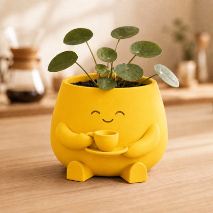 Vaso amiguinho segurando uma xícara com as duas mãos, na cor amarela