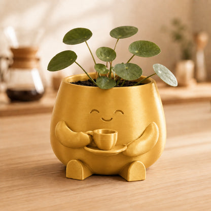 Vaso amiguinho segurando uma xícara com as duas mãos, na cor dourada