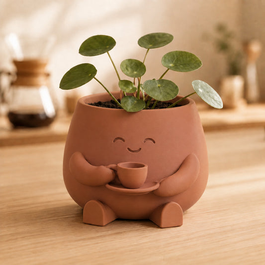 Vaso amiguinho marrom terracota segurando uma xícara com as duas mãos