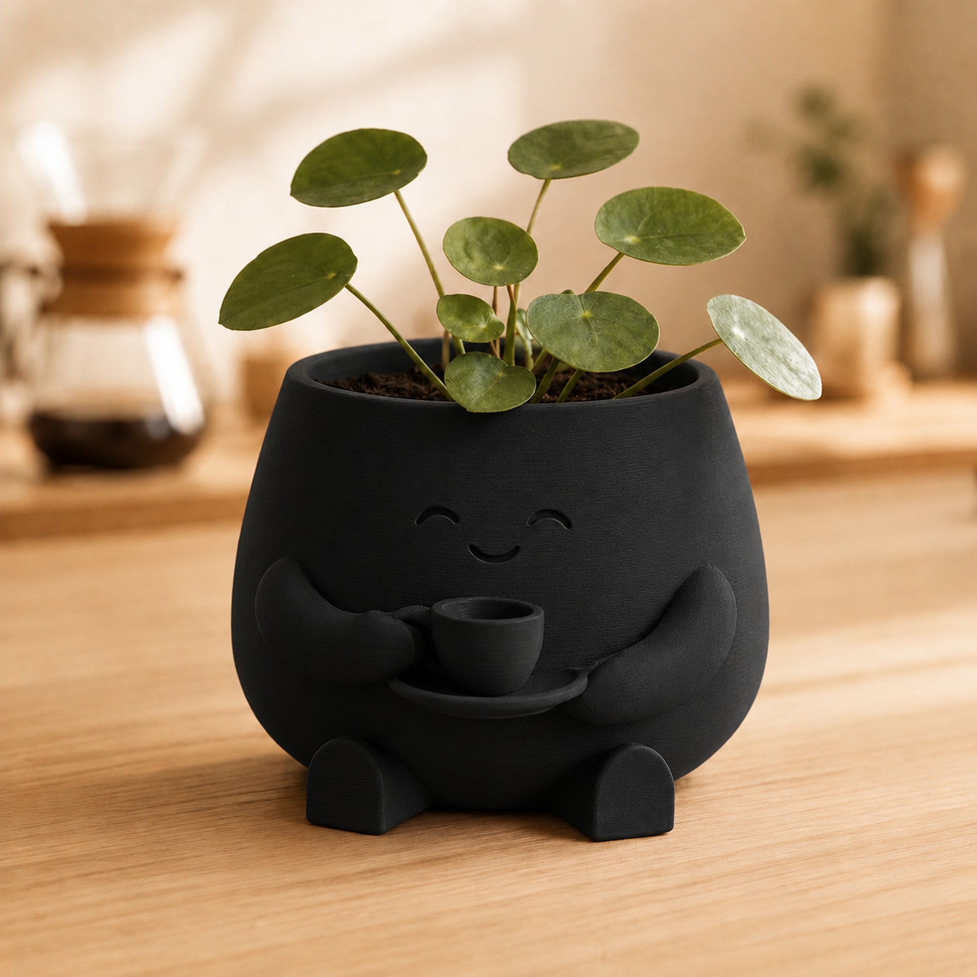 Vaso amiguinho segurando uma xícara com as duas mãos, na cor preta