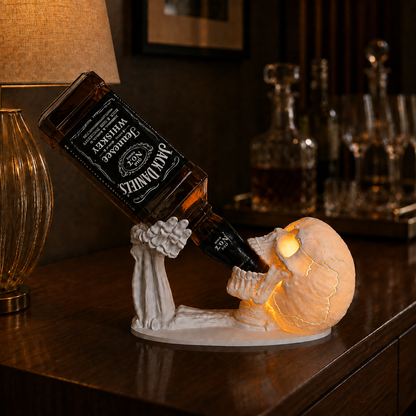 Calavera caveira porta-garrafas branca com luminária acesa, olhos e trincas iluminados, segurando garrafa de whisky sobre aparador de madeira