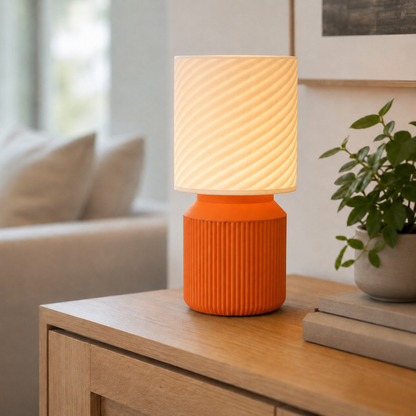 Luminária de mesa japandi com cúpula em espiral acesa, na cor laranja