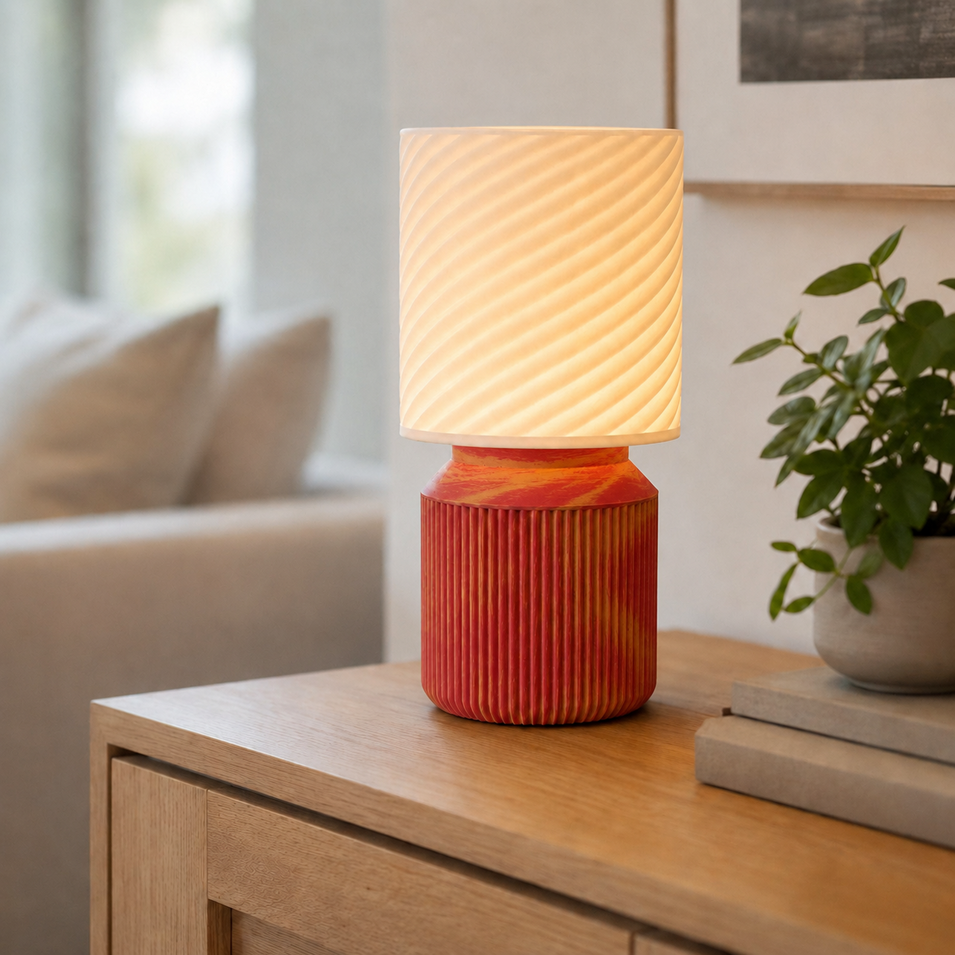 Luminária de mesa japandi com cúpula em espiral acesa, na cor vermelha e dourada