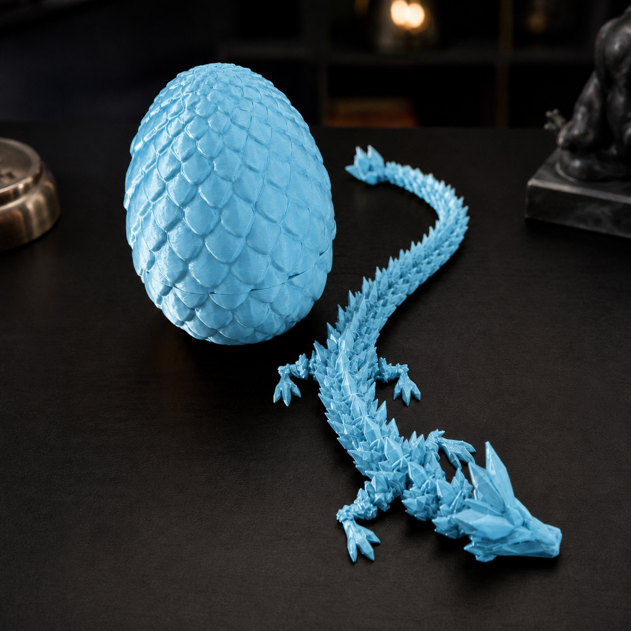 Ovo de dragão que se abre revelando um dragão articulado, na cor azul-celeste