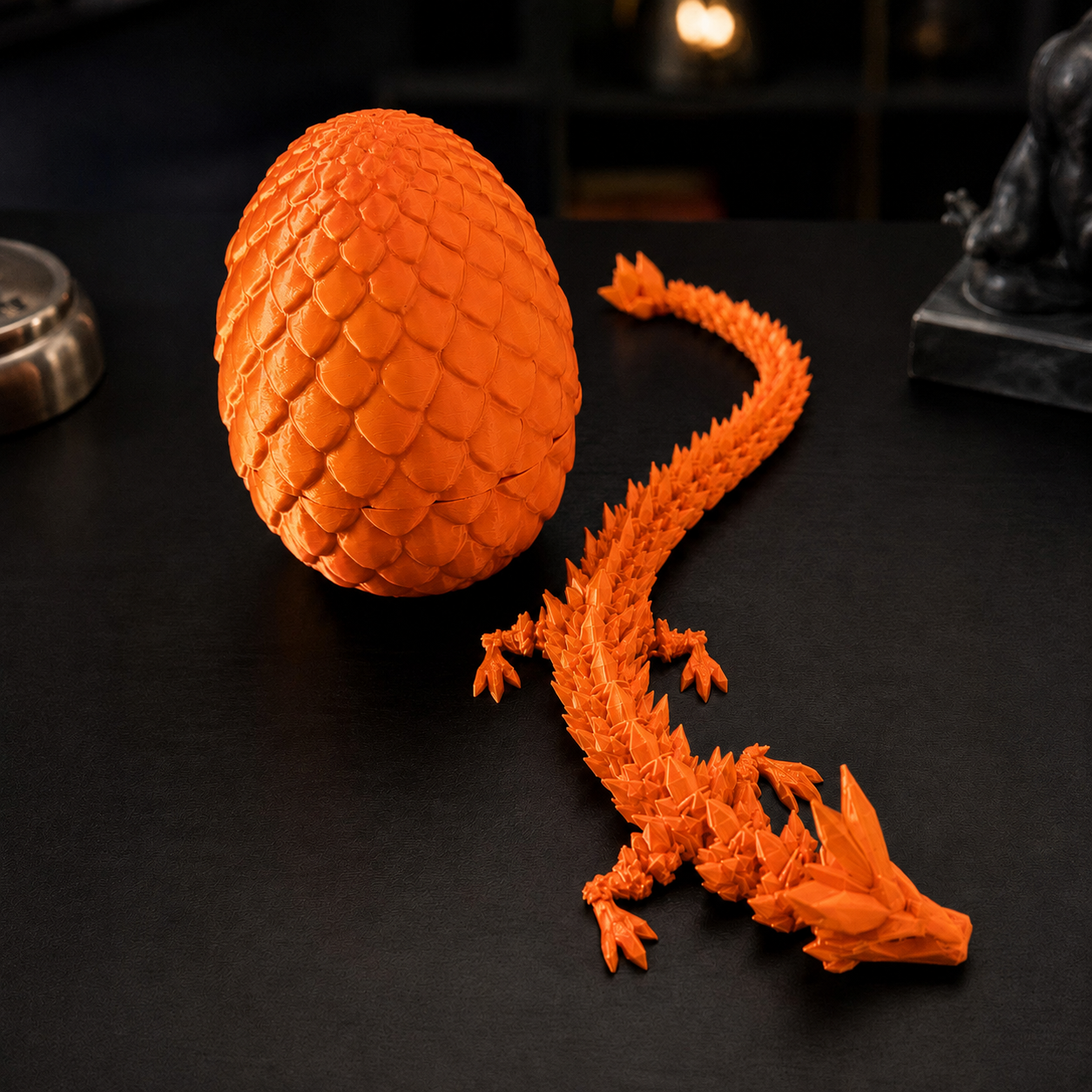 Ovo de dragão que se abre revelando um dragão articulado, na cor laranja