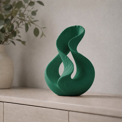 Escultura decorativa com duas curvas entrelaçadas, na cor verde escura