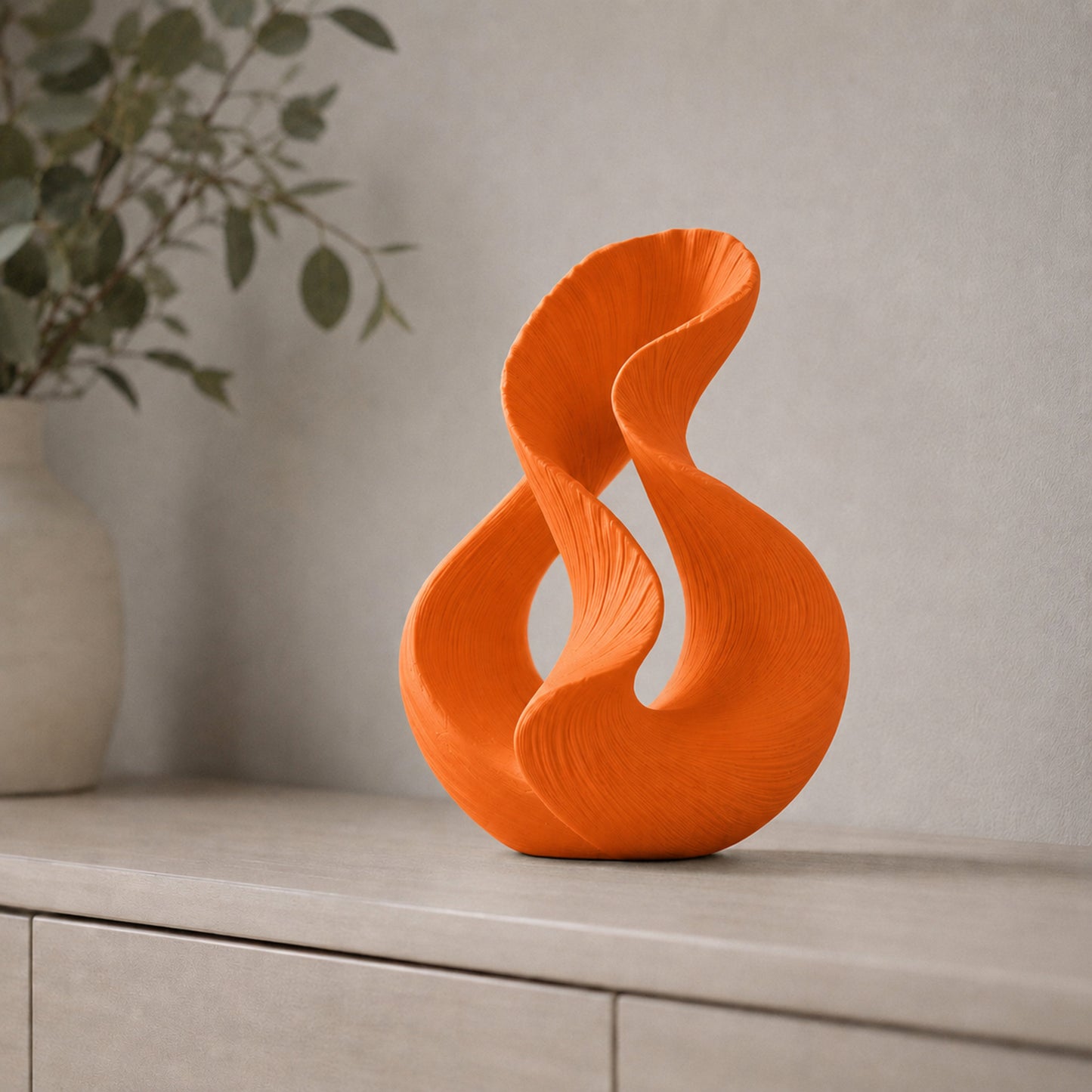 Escultura decorativa com duas curvas entrelaçadas, na cor laranja