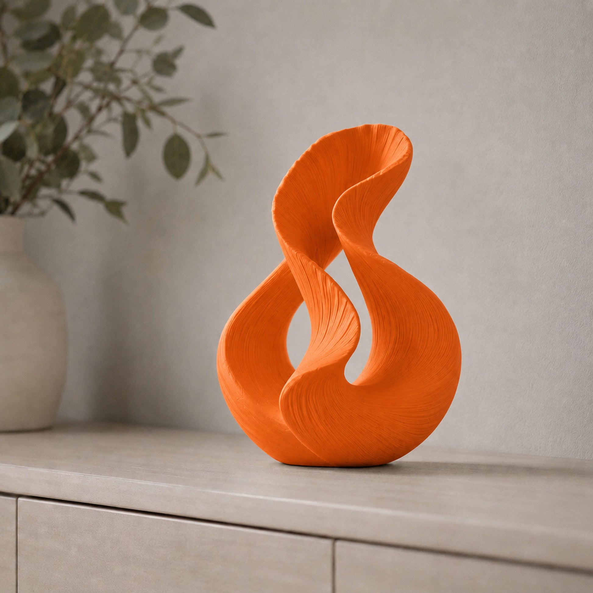 Escultura decorativa com duas curvas entrelaçadas, na cor laranja