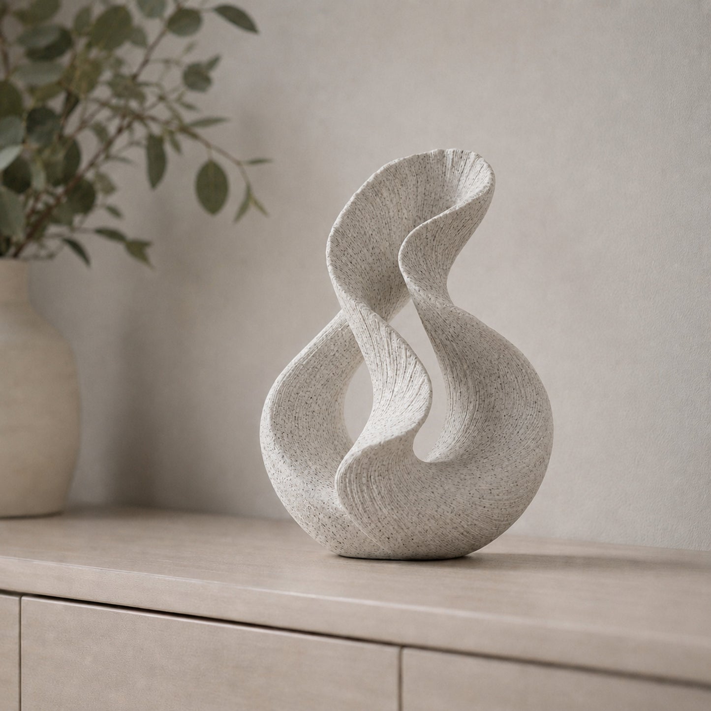 Escultura decorativa com duas curvas entrelaçadas, na cor mármore