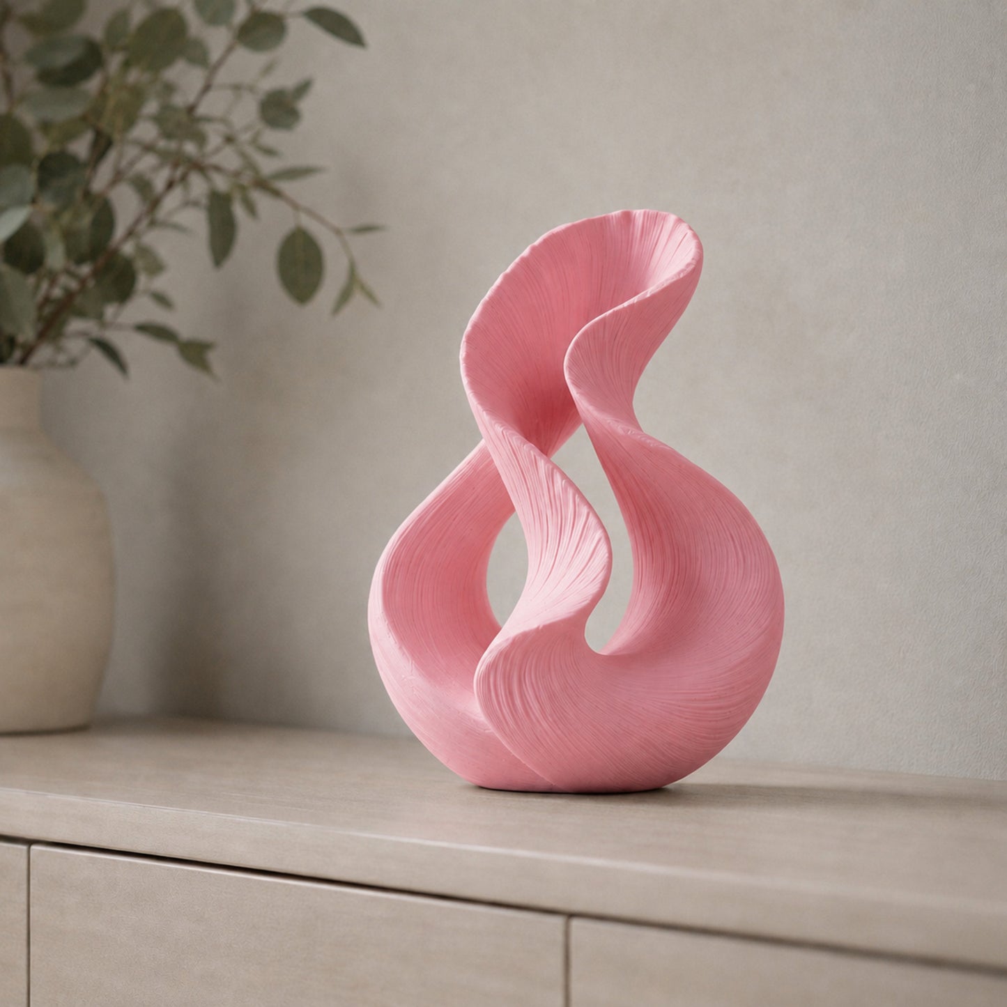 Escultura decorativa com duas curvas entrelaçadas, na cor rosa