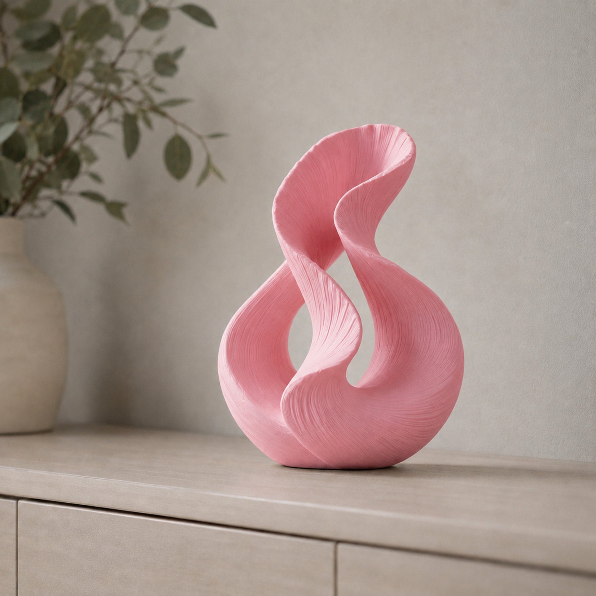 Escultura decorativa com duas curvas entrelaçadas, na cor rosa