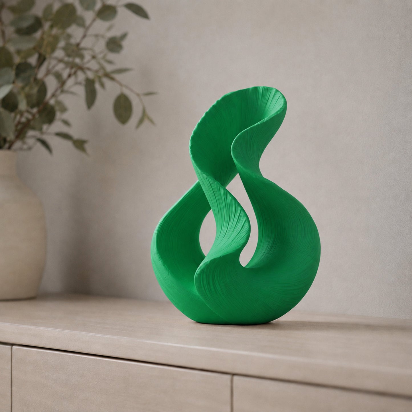 Escultura decorativa com duas curvas entrelaçadas, na cor verde