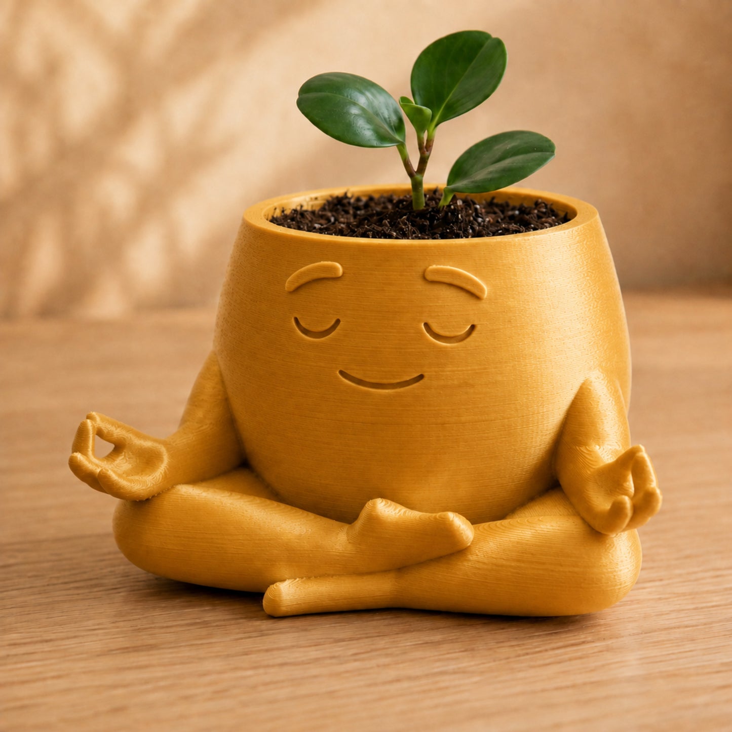Vaso amiguinho meditando em posição de lótus, com carinha serena, na cor dourada