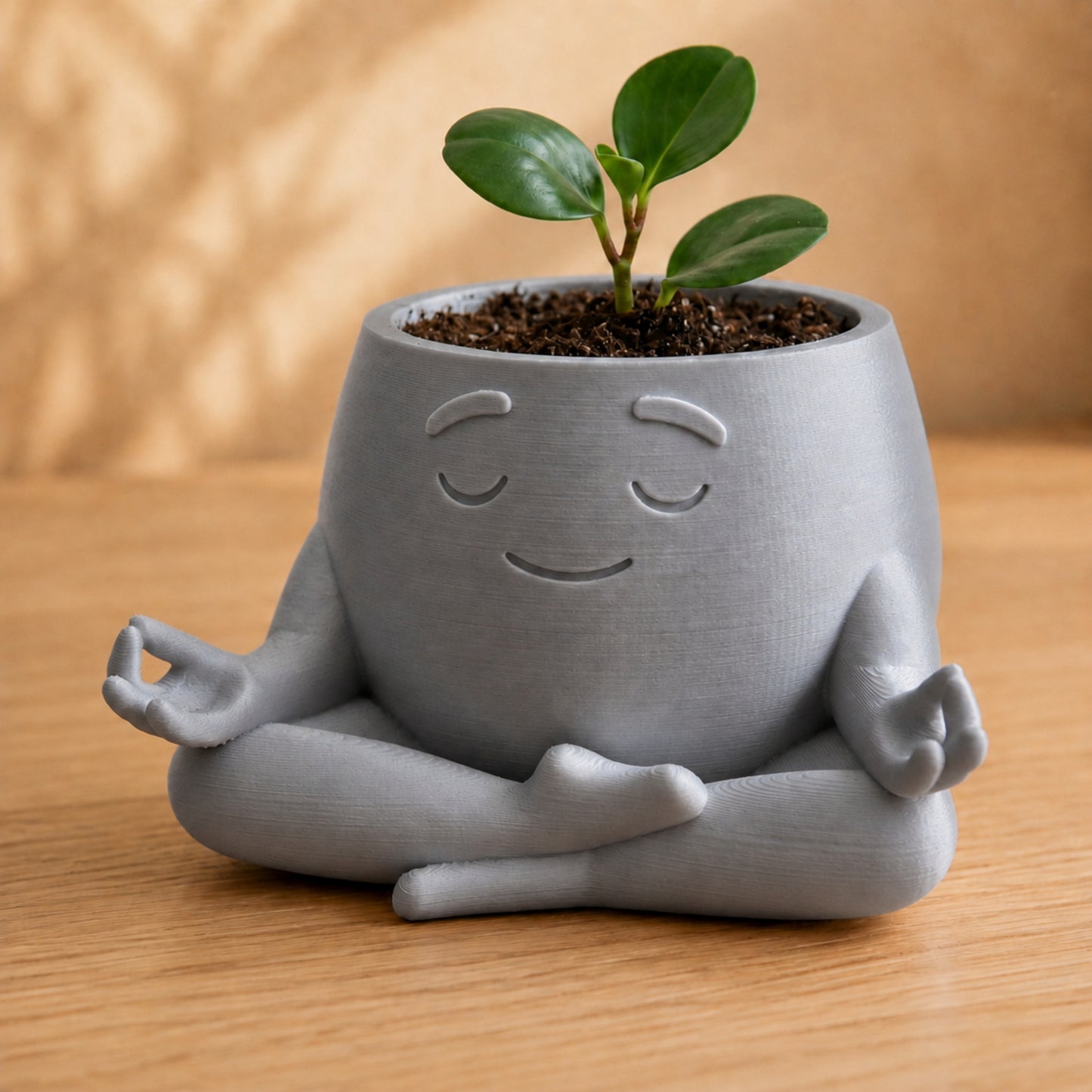 Vaso amiguinho meditando em posição de lótus, com carinha serena, na cor prata