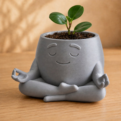 Vaso amiguinho meditando em posição de lótus, com carinha serena, na cor prata